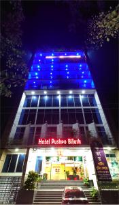 KhulnaHotel Pushpo Bilash的上面有蓝色的灯的建筑