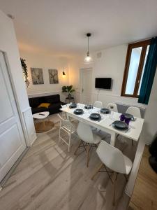 巴涅尔德比戈尔Appartement spacieux - proche centre et therme的客厅配有白色的桌子和椅子