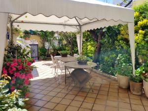 LanzahitaChalet en Valle del Tietar的庭院设有桌子和白色凉亭。