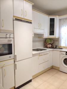 LanzahitaChalet en Valle del Tietar的厨房配有白色橱柜和冰箱。