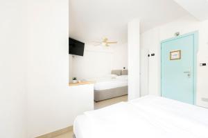 卢加诺Hotel San Carlo的一间白色卧室,配有床和电视