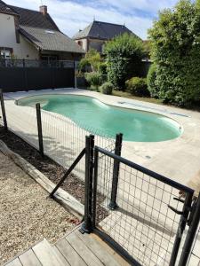 Saint-Mard-lès-RouffyGîte Les Rouffy的一个带围栏的院子内的小型游泳池