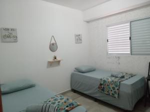 阿蒂巴亚Hospedagem Sol Nascente的白色的客房设有床和窗户。