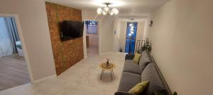 巴亚马雷Matei Apartments的客厅配有沙发和墙上的电视