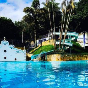 蒂拉登特斯Hotel Ponta do Morro的公园内一个带水滑梯的游泳池