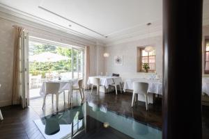 西斯蒂亚纳伊登酒店的餐厅设有桌椅和玻璃地板