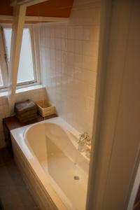 兹沃勒Drostenstraat 5的带浴缸的浴室和窗户