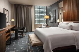 圣路易斯圣路易斯威斯汀酒店的酒店客房设有一张大床和一张书桌。