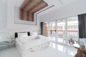 吉利特拉旺安Sea Shell Resort的一间白色卧室,配有床和阳台