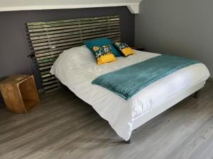 莱鲁斯Au doux passage的一张带绿毯和黄色枕头的大床