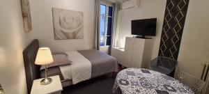 戛纳SeaYouSoon Inn Cannes - Studios的酒店客房设有两张床和电视。