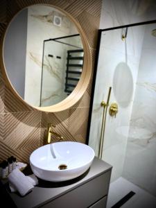 奥斯威辛Słoneczny Apartament Oświęcim的浴室设有白色水槽和镜子