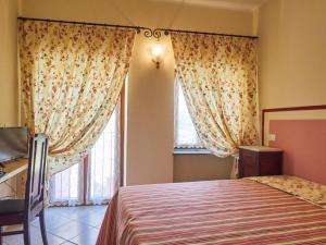 奥拉Eremo dei Poeti的一间卧室配有床和带窗帘的窗户