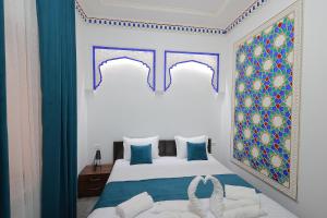 布哈拉Jahangir Boutique Bukhara的一间卧室配有蓝色和白色的床