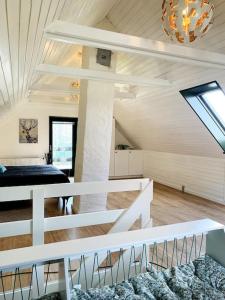HårlevHus på 100 m2 ved skov的白色的客房配有一张床和吊灯