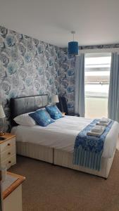布莱克浦HOTEL242的一间卧室配有一张带蓝色和白色床单的床和窗户。