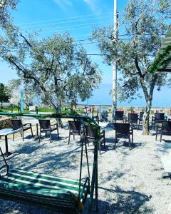 İznikDe La Terrasse IZNIK的一个带桌椅和树木的公园以及秋千