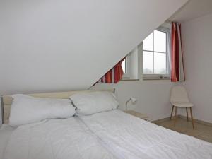 维埃雷格Ferienwohnung Seemöwe im Fährhaus in Vieregge的一间卧室配有一张带白色床单的床和一扇窗户。