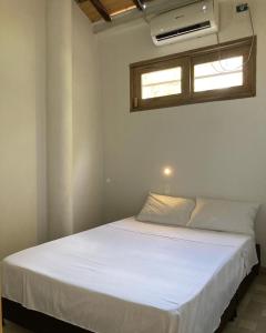 圣安特罗Habitación privada en la playa HappyBeach_co的窗户客房内的一张白色床