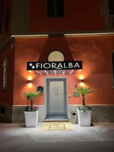 米兰Hotel Fioralba的两棵盆栽植物的建筑物一侧的门
