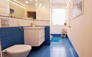 格但斯克Marine Apartament的浴室设有白色卫生间和蓝色瓷砖。
