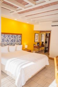 恩塞纳达港波萨达埃雷伊索尔酒店的卧室配有白色的床和黄色的墙壁