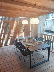 比奥格勒·纳·莫鲁Ana Mobile Home - Kamp Soline - Biograd na Moru的木甲板上的餐桌和椅子
