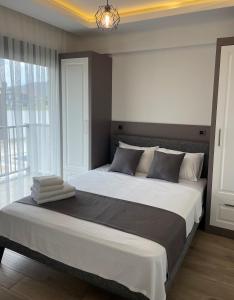凯麦尔KALİDA APART的卧室设有一张大床,卧室设有大窗户