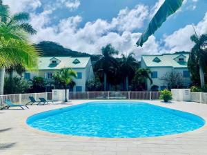 Saint MartinSeadream Paradise appartement vue piscine à 150m de la plage的一座房子前面的蓝色海水大型游泳池