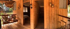 马尔多纳多港PAMPA HERMOSA LAKE RESORT的木屋设有门廊和卧室