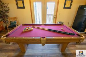 布兰森Forest Heights Lodge - 6BR - Pool Table - Near Silver Dollar City - FREE TICKETS INCLUDED的一张台球桌,上面有球和筷子