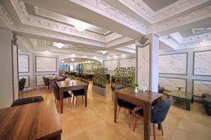 伊斯坦布尔Istanbul Panorama Hotel的餐厅设有木桌、椅子和窗户。