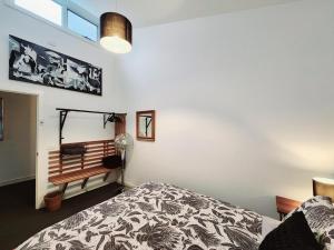 Cape WoolamaiModern 3 bedroom apartment, beach, surf & shops的卧室配有一张床,墙上设有长凳