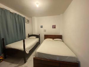 曼塔Playa Aparts & Suites Malecon的带窗户的客房内设有两张单人床。