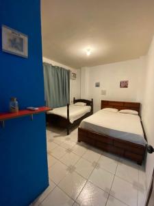 曼塔Playa Aparts & Suites Malecon的一间卧室设有两张床和蓝色的墙壁