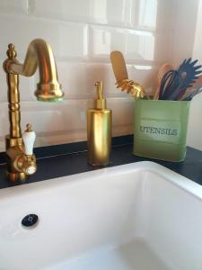 安科纳AN Deluxe Suites的浴室水槽设有金色水龙头和水槽