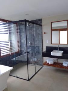 费尔南多 - 迪诺罗尼亚Pousada Ecológica Akanã的一间带玻璃淋浴和水槽的浴室