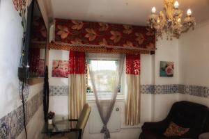 格拉斯哥Luxurious Serviced rooms in Glasgow的客房设有带窗帘和吊灯的窗户。