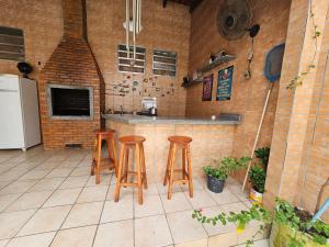 马瑙斯Pousada 218 Manaus的厨房配有3张吧台凳和1个柜台