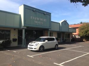 墨尔本Evancourt Motel Malvern East的停在大楼前停车场的白色汽车