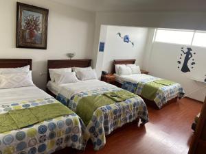 拉塔昆加Loreto hotel的酒店客房设有两张床和窗户。