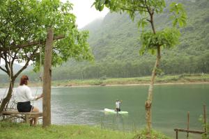 峰牙Phong Nha A Little Leaf Homestay的水中桨板上的人