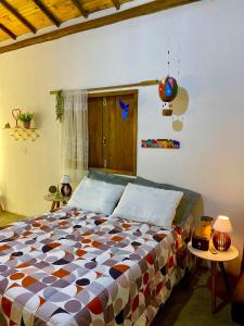 卡兰卡斯Chale Pepe的一间卧室配有一张带五颜六色棉被的床