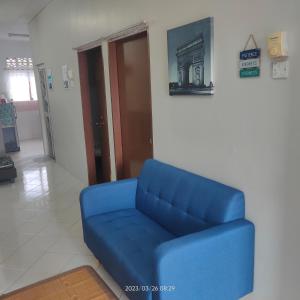 马日丹那Sri Bayu Bidara Palma的一张蓝色的沙发,坐在带门的房间