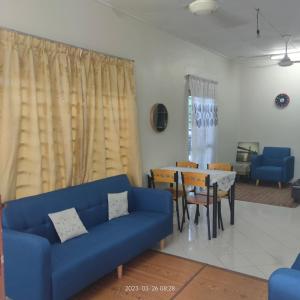 马日丹那Sri Bayu Bidara Palma的客厅配有蓝色的沙发和桌子