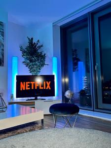 曼彻斯特Salford Quays Apartment, Manchester的客厅里设有一台带网格标志的电视