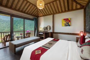 萨帕Sin Chai Ecolodge的一间带大床的卧室和一个阳台