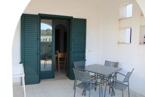 奥特朗托Blu Mare Frassanito - Residence的一个带桌椅和门的庭院