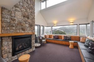 佩里舍峡谷Kooloora Lodge的客厅设有壁炉和石墙