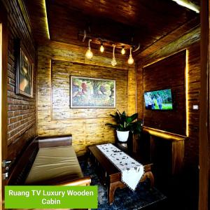 KejajarBagas Luxury Camp的一间带长凳和电视的客厅